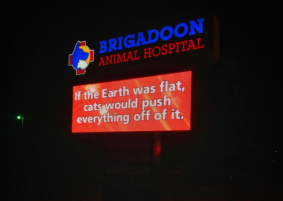 Brigadoon Animal Hospital lit LED pylon sign at night with message board