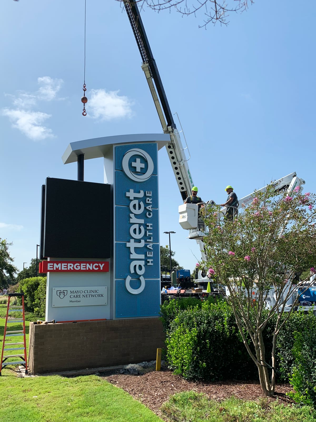 Crane and bucket crew installing the Carteret Health Care pylon with LED cabinet