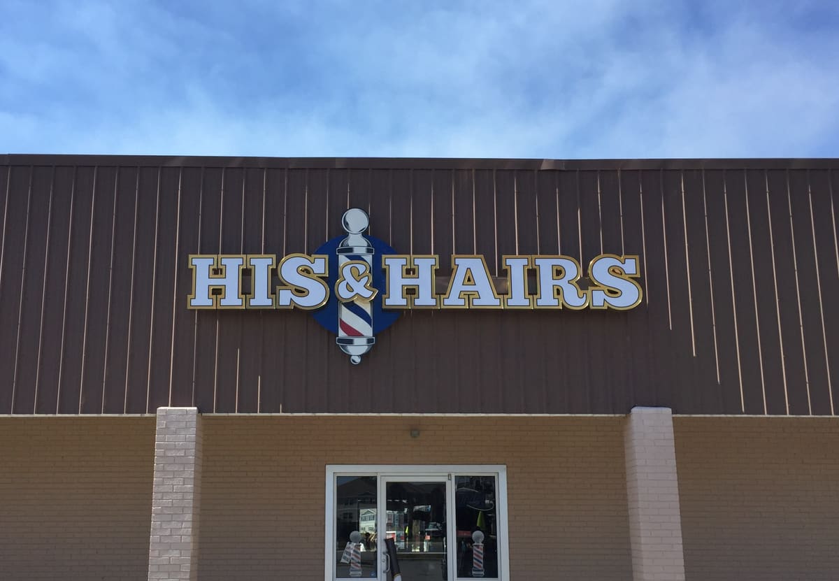His & Hairs barbershop channel letters with barber-pole logo on a brown metal facade