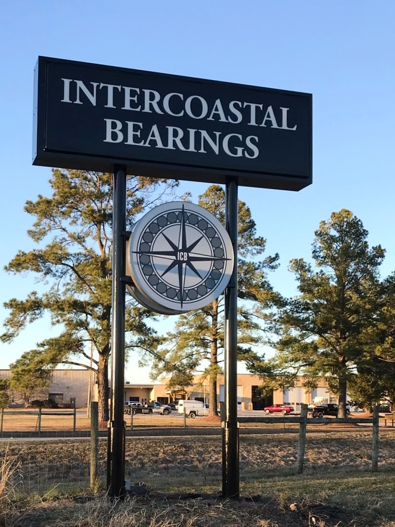 Intercoastal Bearings pylon with round compass-logo cabinet in golden evening light