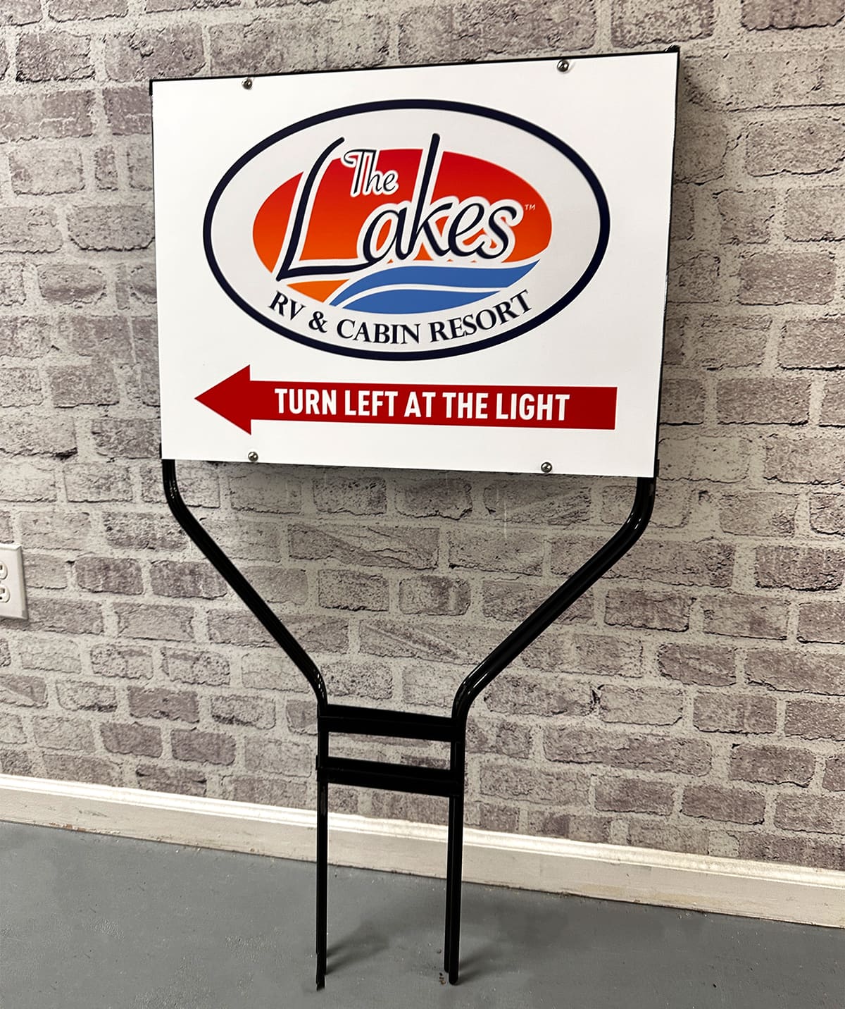 The Lakes RV & Cabin Resort directional yard sign in a black metal frame
