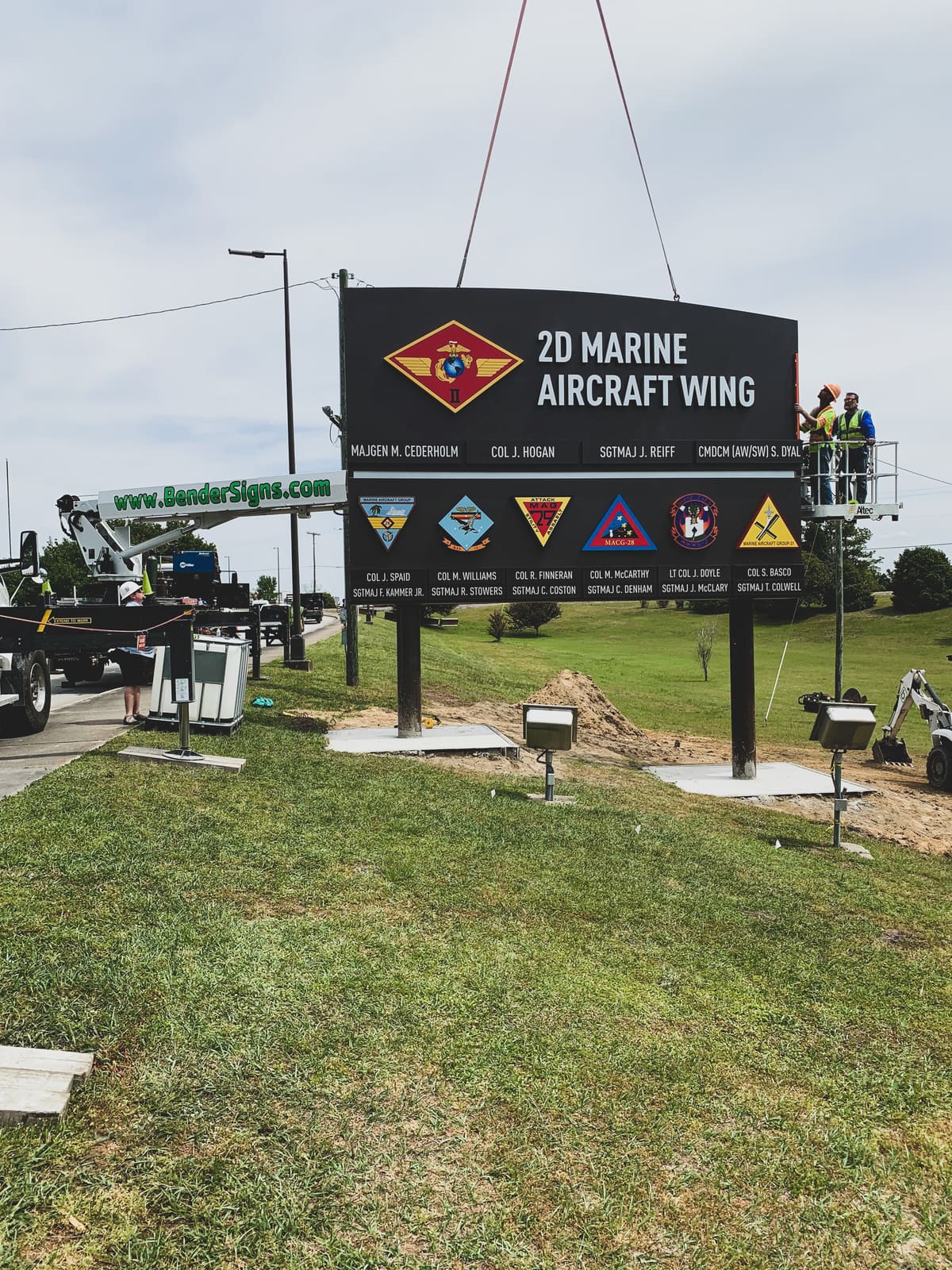 Crane setting the 2D Marine Aircraft Wing command board with crew on a lift at Cherry Point