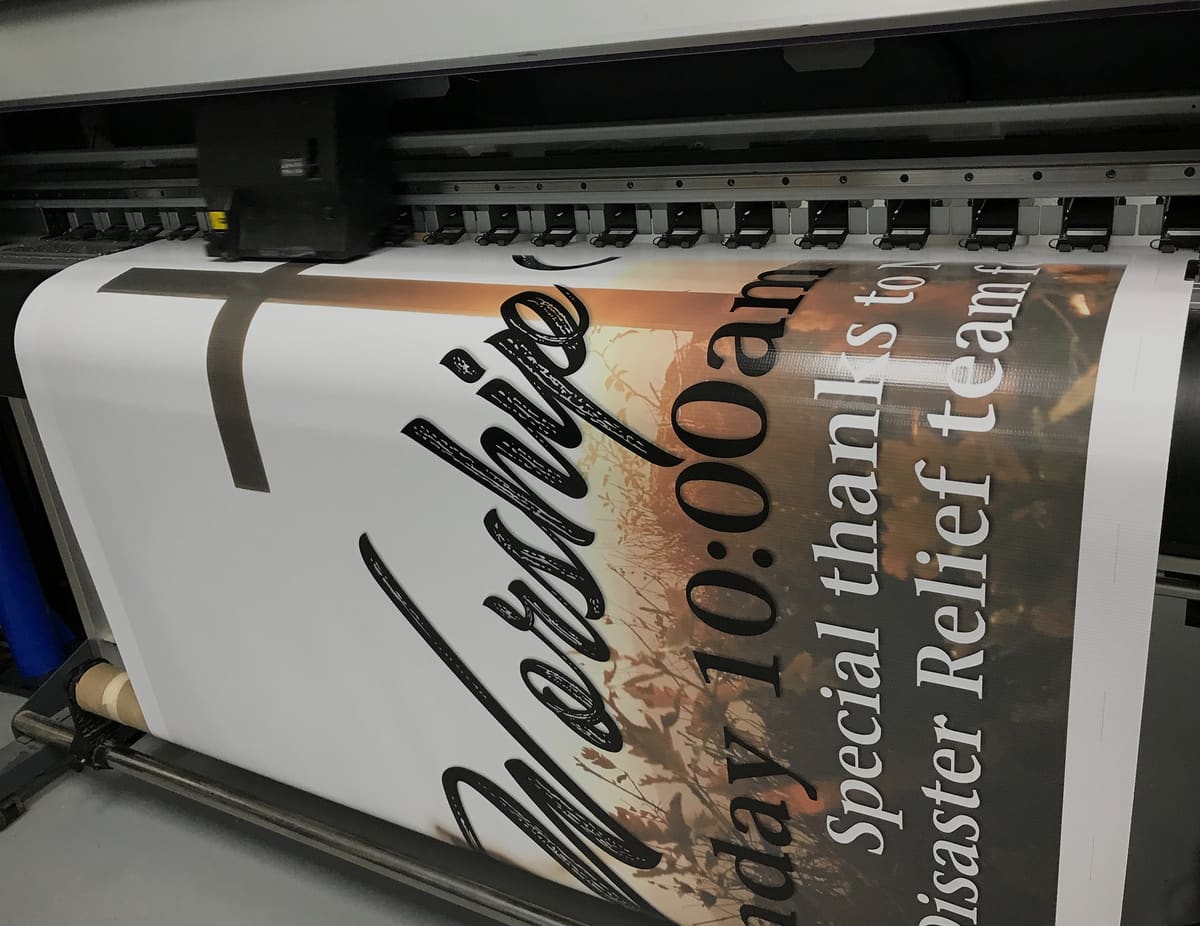 Large-format printer running a church worship banner in the Bender print shop