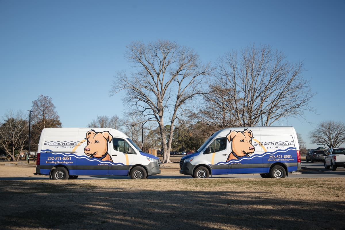 Pair of River Dog Plumbing wrapped Sprinter vans in winter light