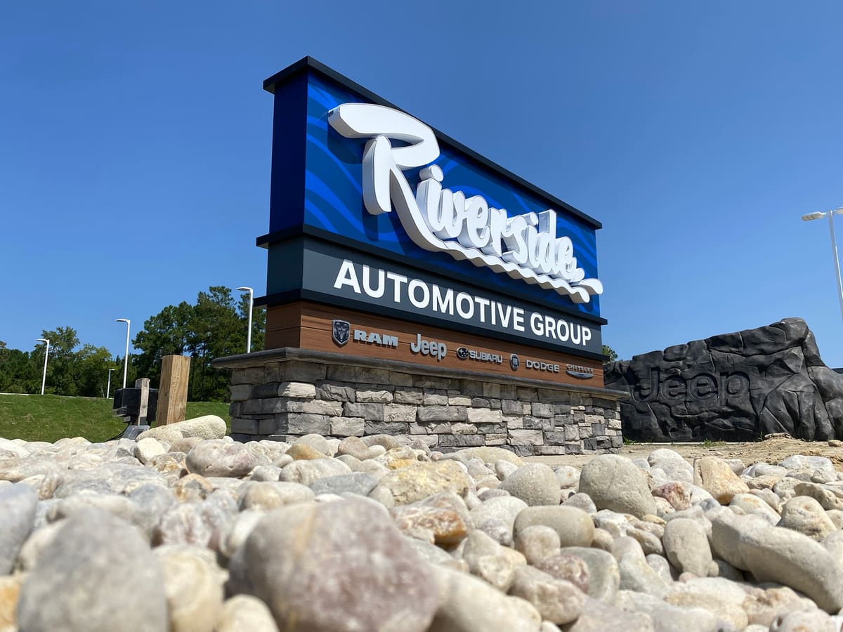 Riverside Automotive Group monument sign with stone base and channel lettering, low angle