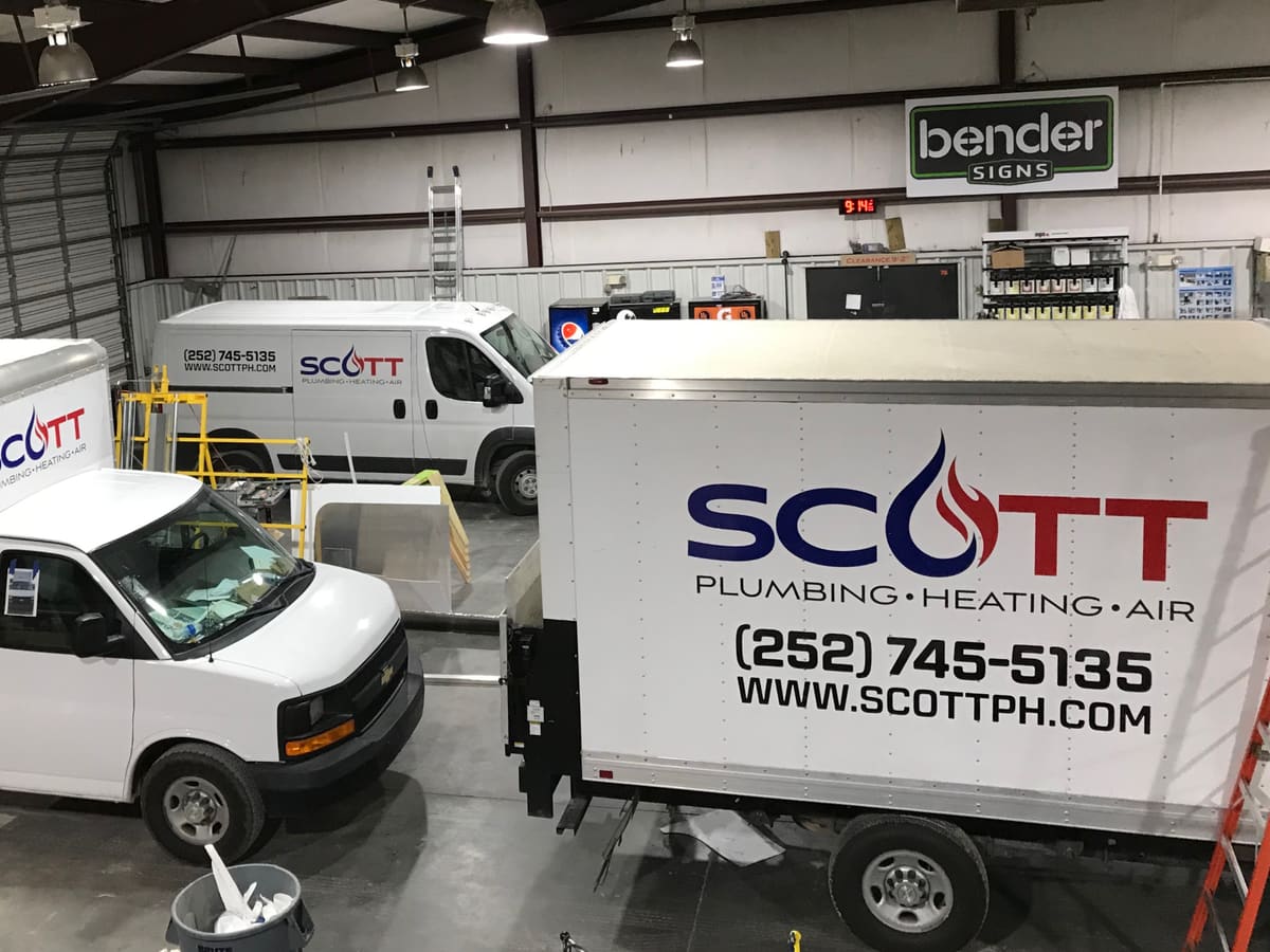Scott Plumbing Heating Air fleet vehicles freshly lettered inside the Bender shop