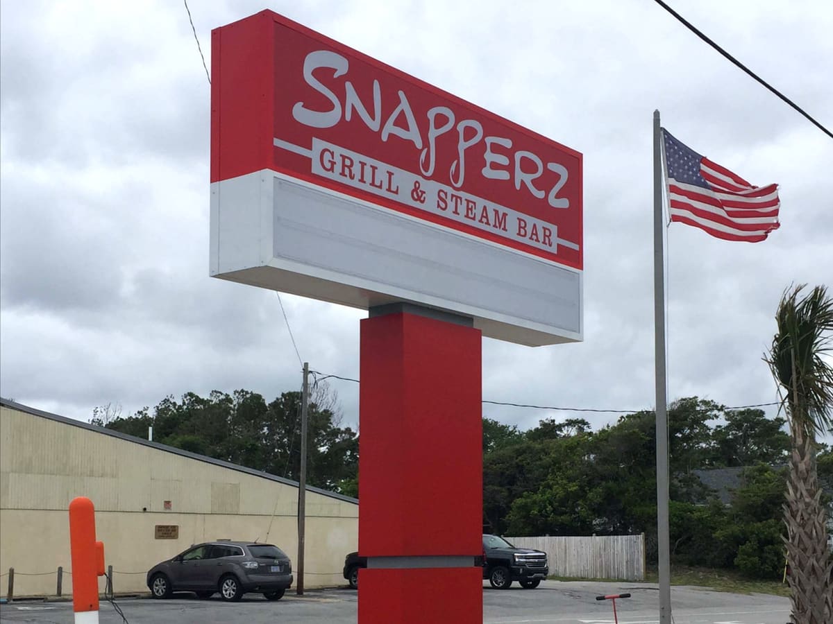 Snapperz Grill & Steam Bar pylon sign with reader board and US flag