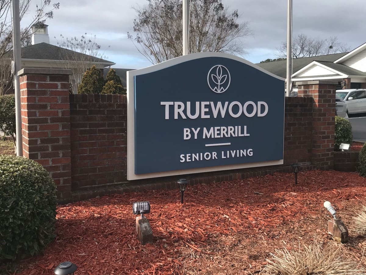 Truewood by Merrill senior living monument sign between brick columns with fresh landscaping