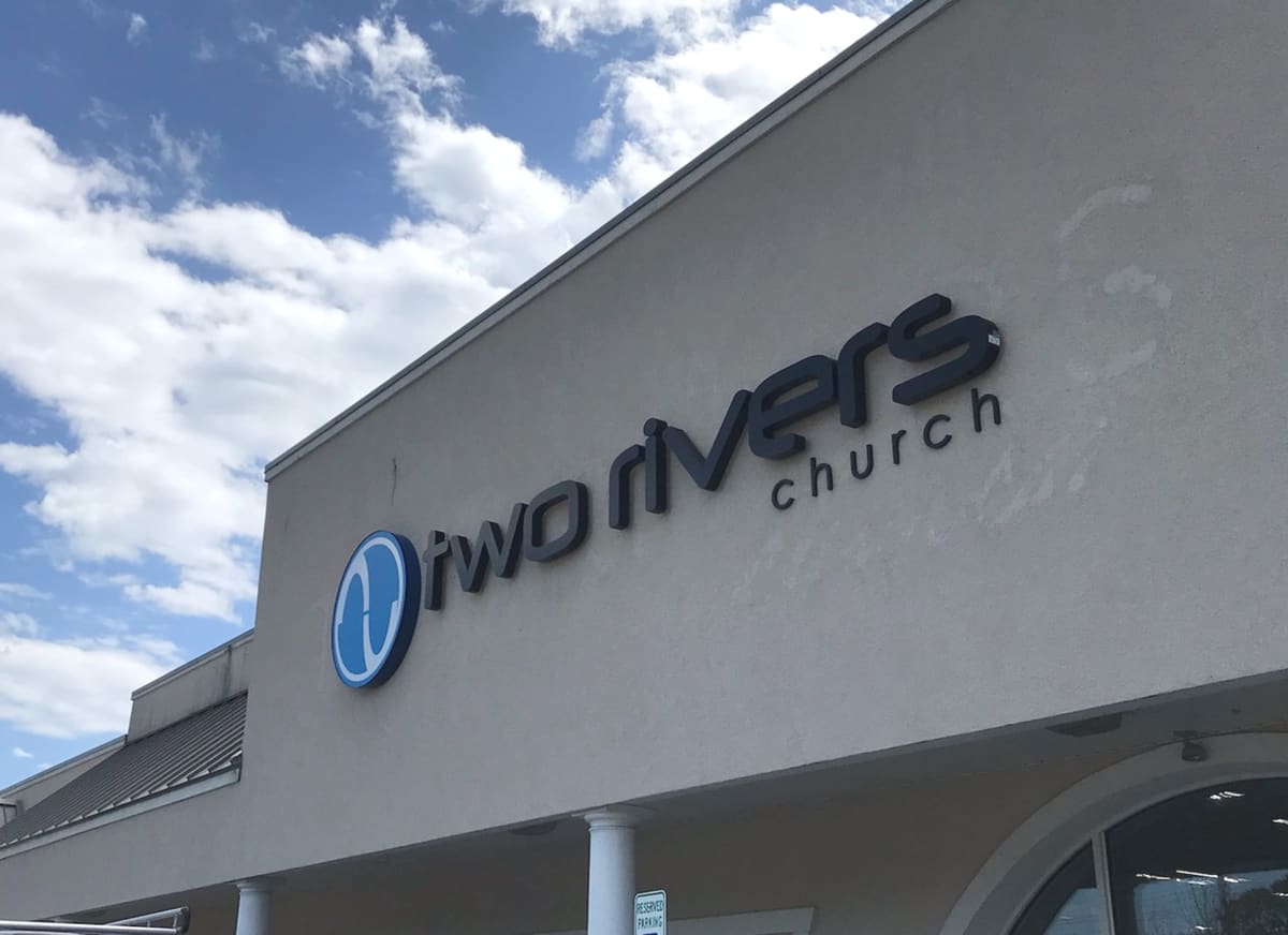 Two Rivers Church channel letters and round logo on a stucco facade