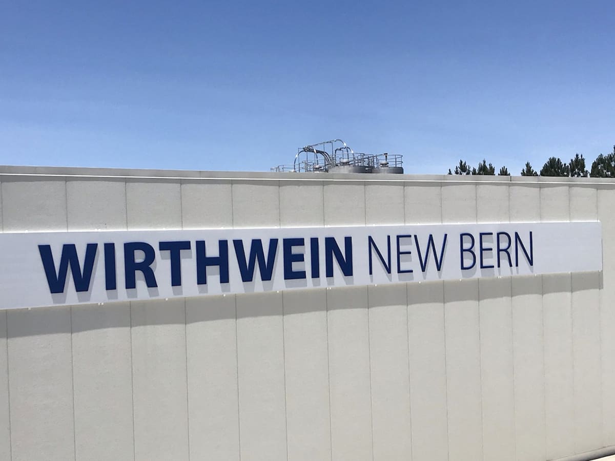 Wirthwein New Bern dimensional letters on a white industrial building under a clear sky